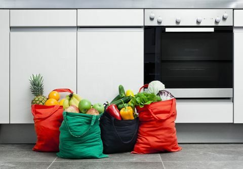 Торбички за многократна употреба, пълни с плодове и зеленчуци в кухня.