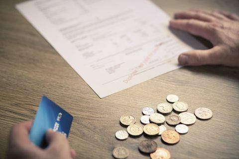 Мъни ръце, държащи кредитна карта с монети и сметка на масата