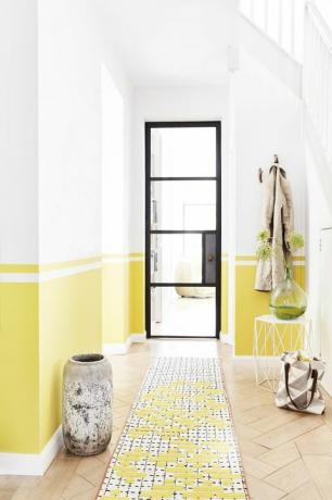 коридор с черна рамка на врата, стените са боядисани в жълто наполовина нагоре от долната линия. Внимателно използване на тиксо и Нивелирът е ключът към създаването на този линеен ефект на боядисване, боядисвайте всяка секция на свой ред и я оставете да изсъхне, преди да преминете към следващата един