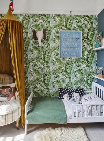 детска спалня с тапет с принт на тропически палми и жълт балдахин