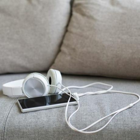 слушалки и смарт телефон на дивана