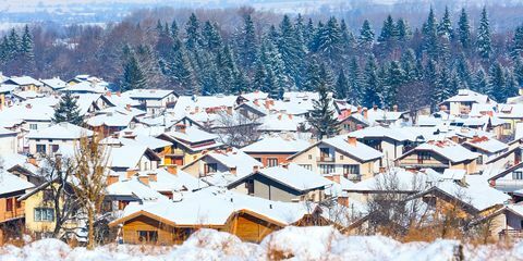 Къщи със снежни покриви панорама в българския ски курорт Банско