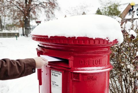 Човек, който публикува писмо в заснежена британска пощенска кутия