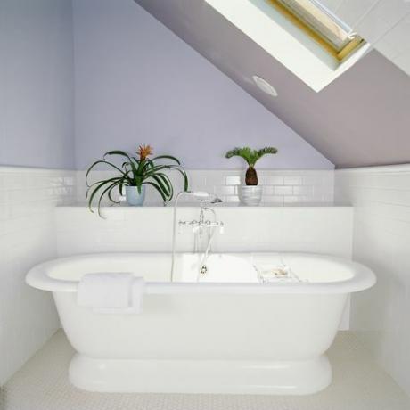 вана под прозореца в таванска баня с лилаво лилави стени