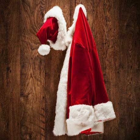 костюм на Санта, окачен на дървена стена, изстрелян с наклон и леща за смяна