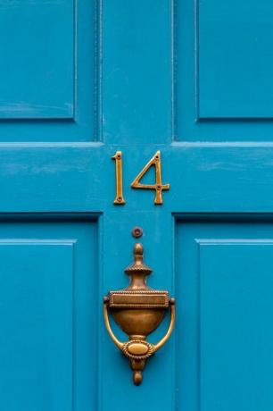 синя входна врата с месингов чук за врата