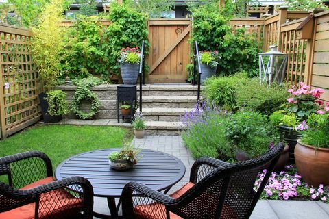 Малка градинска градина с мебели за вътрешен двор сред цъфтяща лавандула