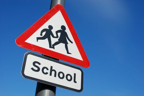 Училищни деца, пресичащи знак с копие пространство