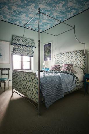 Синя спалня с тапицерия с принт с птици и легло с балдахин