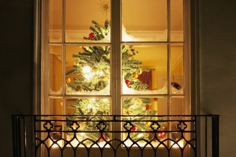 Коледни орнаменти на дърво зад прозореца