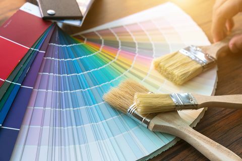 Работна маса за художник и декоратор с проект за къща, цветни образци, валяк за рисуване и четки за боядисване