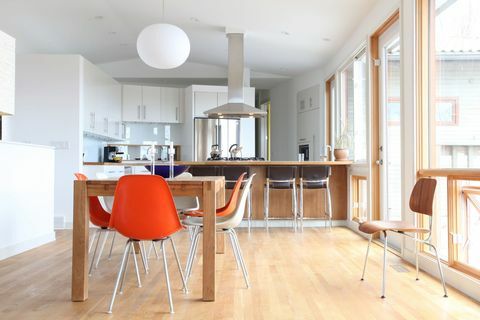 Модерна шведска кухня: Чиста бяла модерна кухня с цветни модерни кухненски столове от средата на века